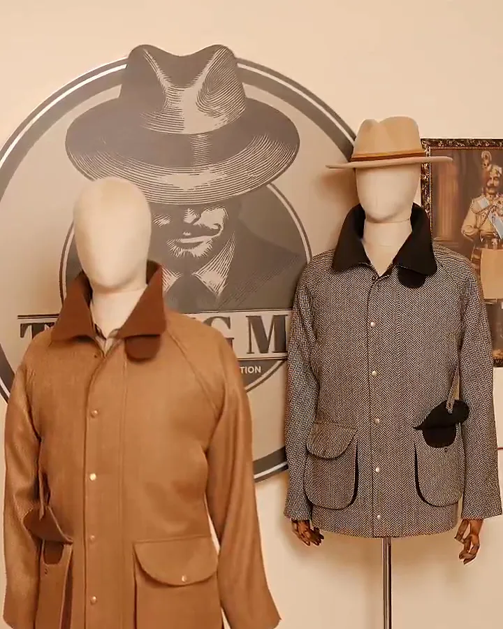 Inside THE BIG MAN studio in Phase 7, Mohali: two dress forms wearing a camel field coat and a herringbone shooting coat in front of the house mark painted on the wall